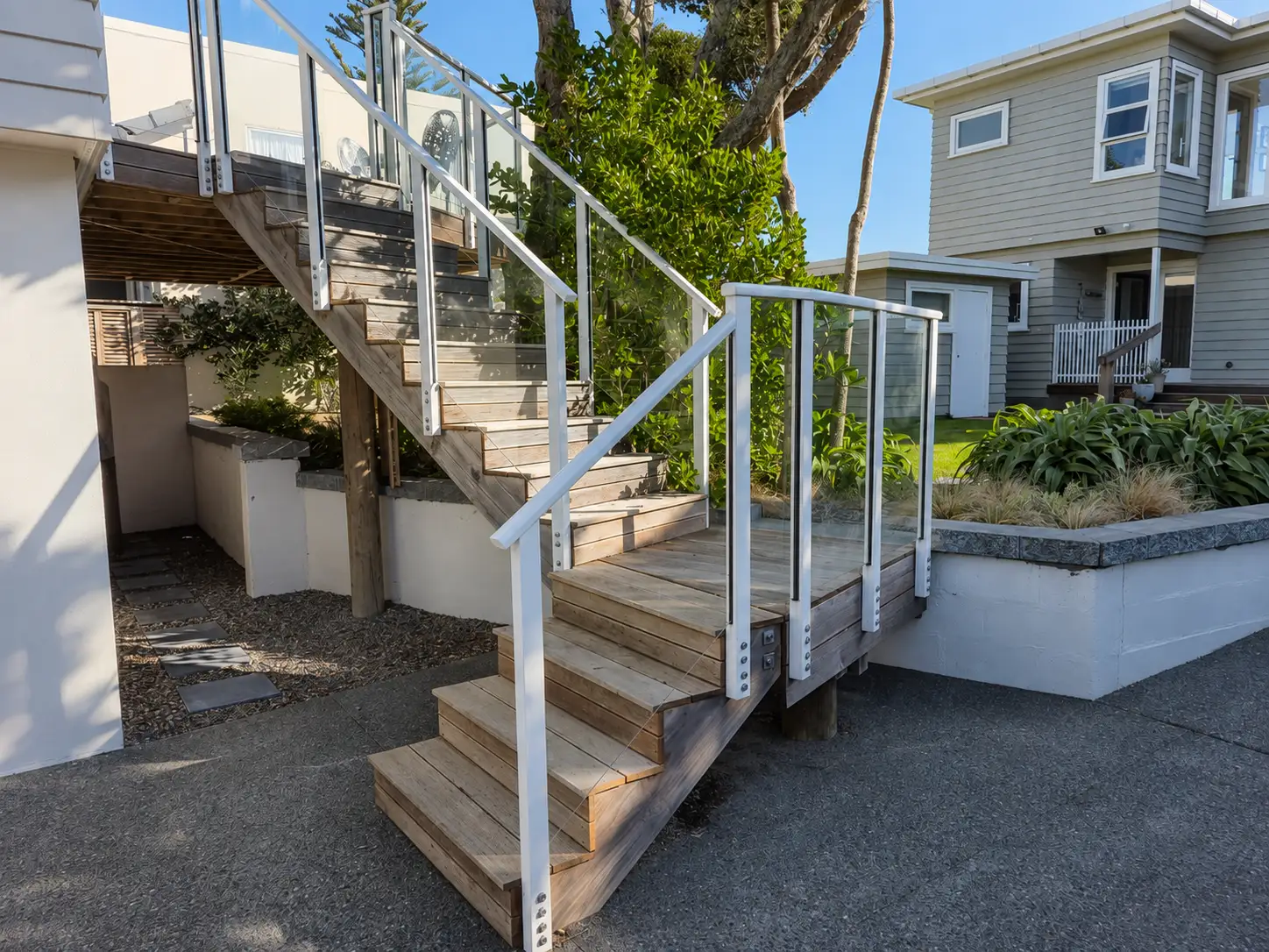 The same stair from the foot of the drive, with the flight running up the flank of the house and the tree the build had to be worked around standing over it.